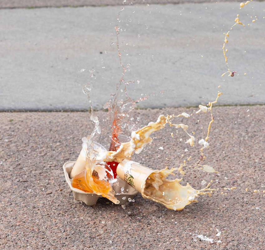 Action shot of a coffee drink splashing on the pavement