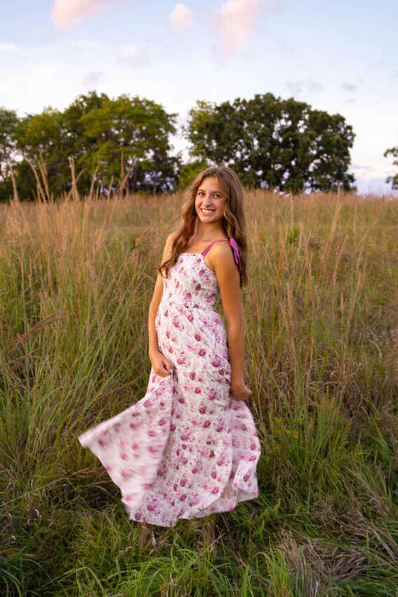 Senior girl twirling in a long floral dress