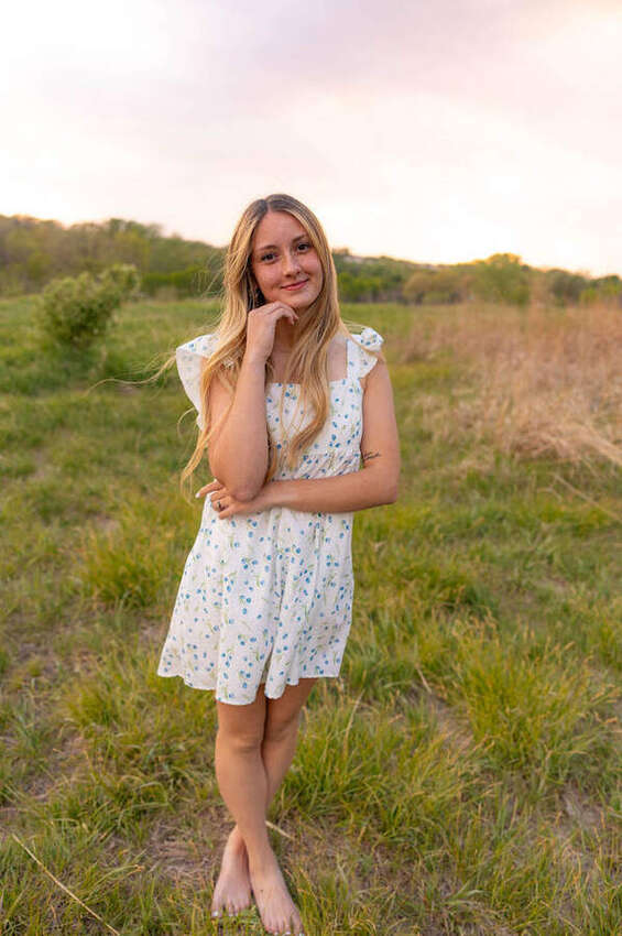 Senior girl standing in a blue floral dress at golden hour