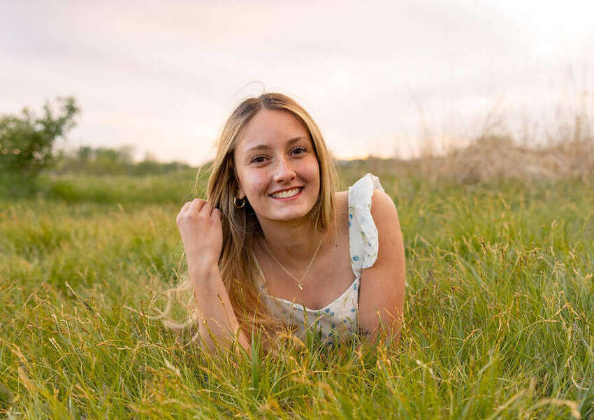 Senior girl smiling while lying in the grass