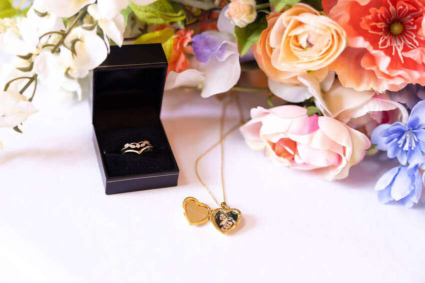 Wedding ring in a box beside colorful flowers