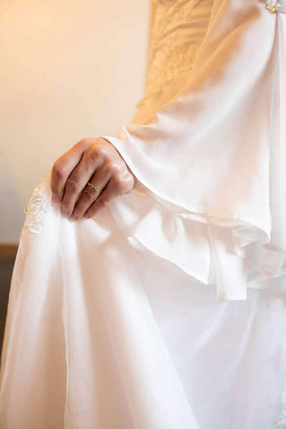 Close-up of a bride holding her flowing white sleeve