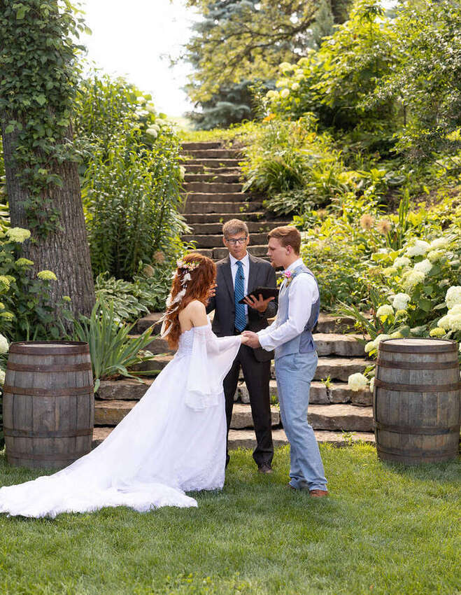 Wedding ceremony on a stone staircase surrounded by greenery