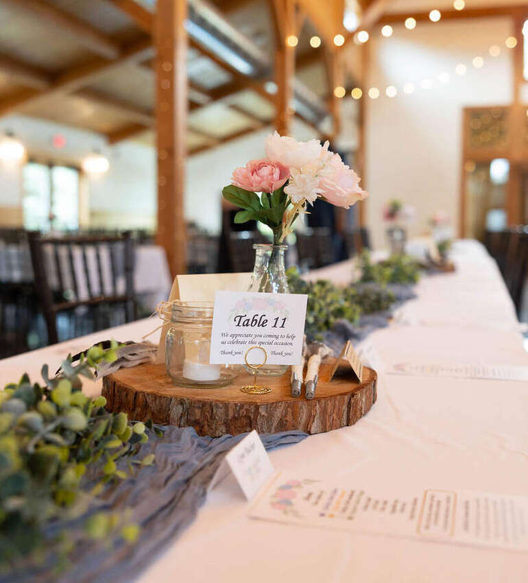 Rustic wedding reception table with flowers and a Table 11 card
