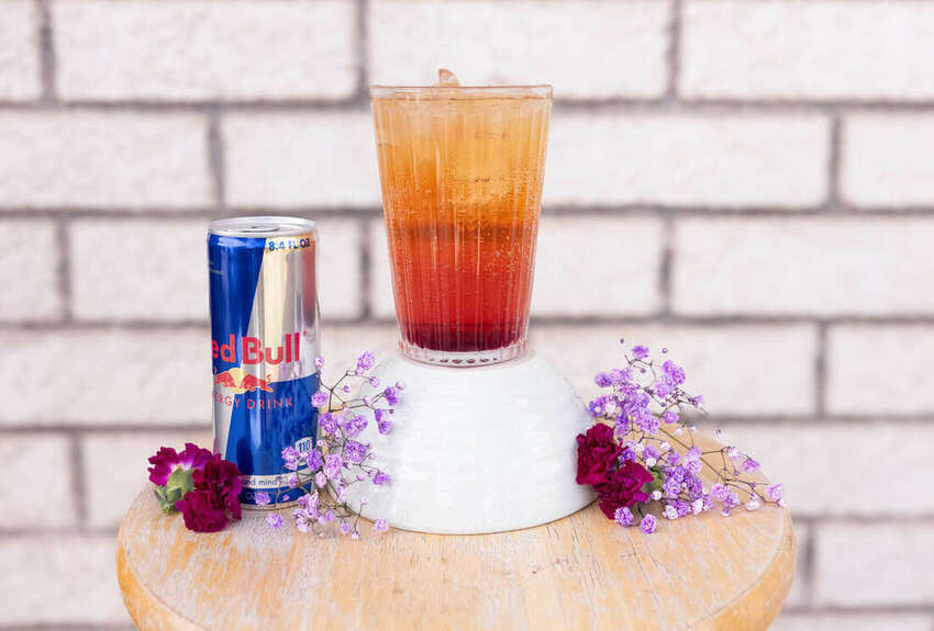 Styled drink photo with a Red Bull can and flowers